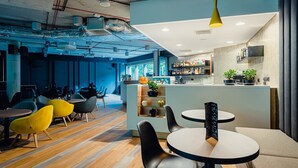 A modern bar area with a counter, seating, and a variety of plants.