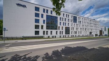 Ein modernes Gebäude mit heller Fassade und zahlreichen Fenstern.