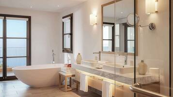 Une salle de bain moderne avec une baignoire sur pieds, un meuble-lavabo doté d’un grand miroir et une cabine de douche en verre.