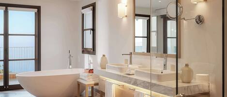 A modern bathroom with a freestanding bathtub, a vanity with a large mirror, and a glass shower enclosure.