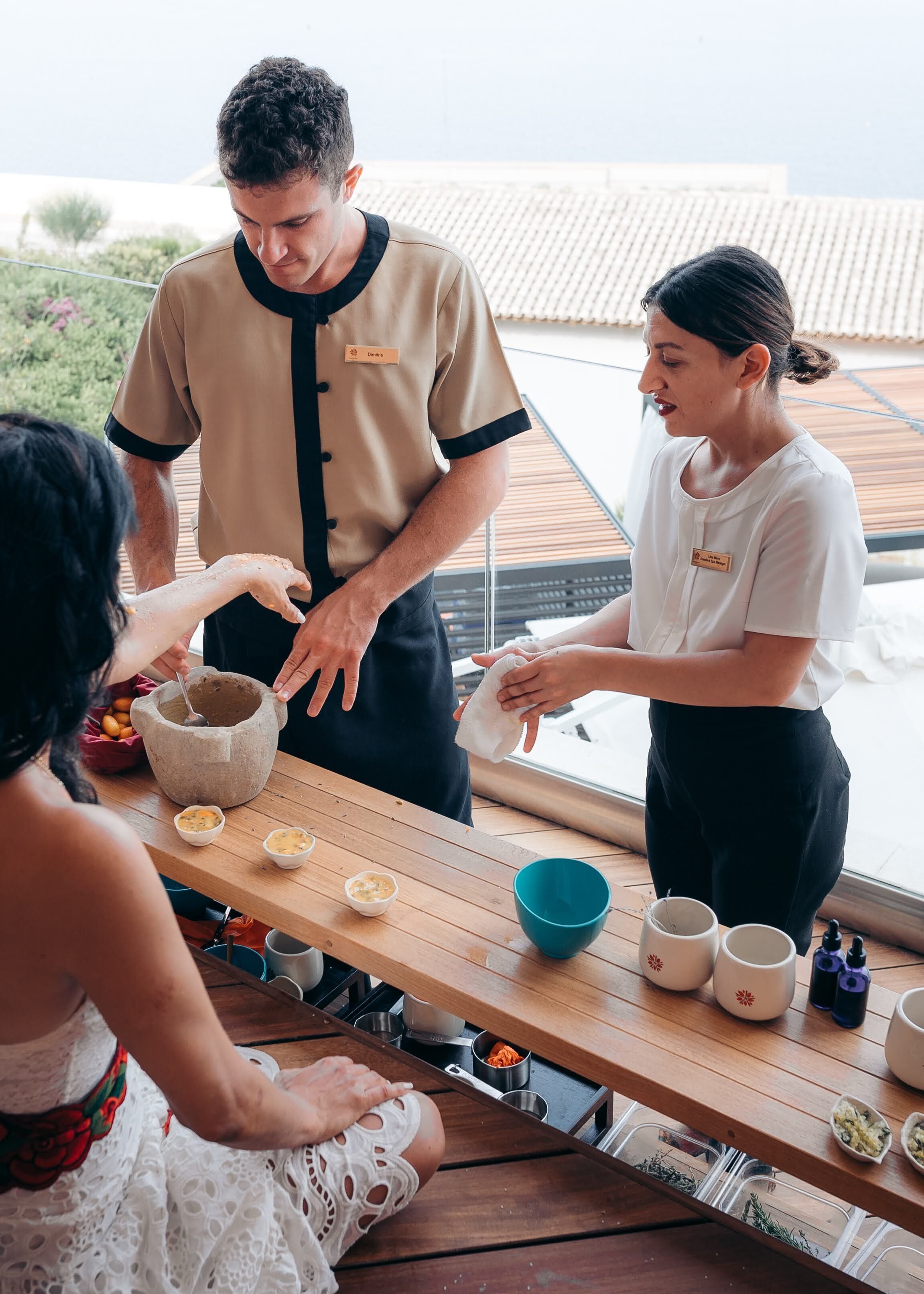 Een eetgedeelte met een houten tafel, een schaal eten en een persoon die eten serveert.
