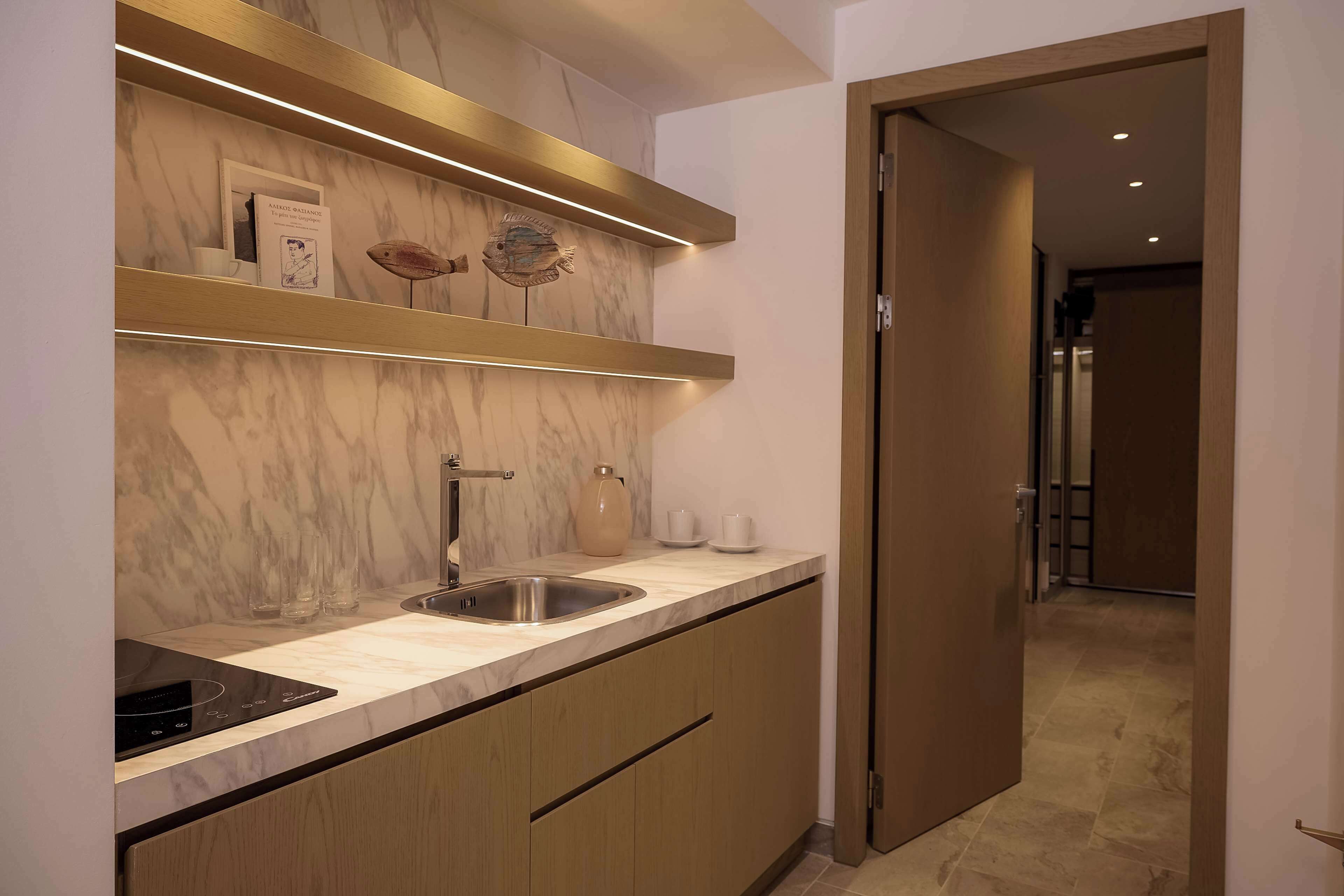 A modern kitchen with marble countertops, a built-in sink, and wooden cabinets.