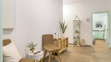 Relax in a comfortable seating area with a sofa and chair, surrounded by a clean, minimalist design.