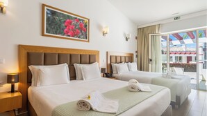 A hotel room with two beds, a painting of flowers on the wall, and a view of the outside. - Hotel Rural Brícia du Mar (Lagoa)