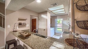A kitchen with granite countertops, a sink, and a window.