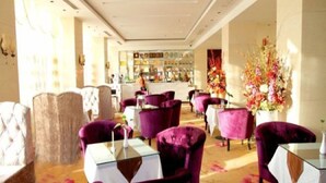 A hotel lobby with purple armchairs, a bar area, and a floral arrangement. - Beijing Huihao International Hotel (Beijing)