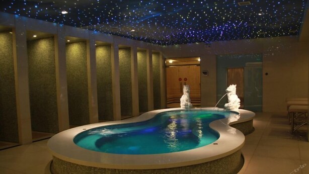 A spa area with a hot tub and two white statues, a starry ceiling, and a tiled floor. - Beijing Huihao International Hotel (Beijing)