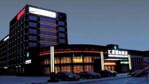 A modern building with multiple floors and a large illuminated sign. - Beijing Huihao International Hotel (Beijing)
