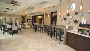 A spacious kitchen with a central island, bar area, and dining space with chairs. - Solterra Resort Pool & Spa, Games Room, Lake View & Extensive Resort Amenities (Davenport)