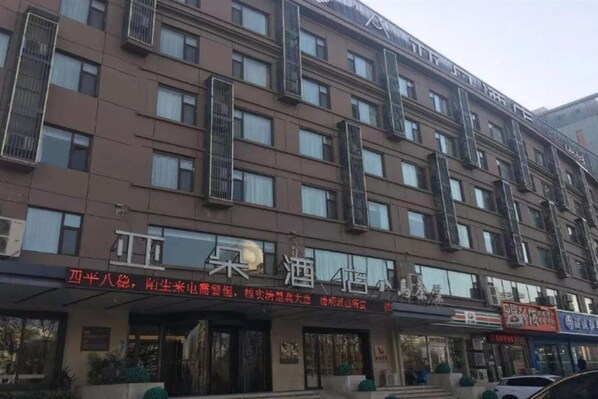 A multi-story hotel with a brown facade and multiple balconies.