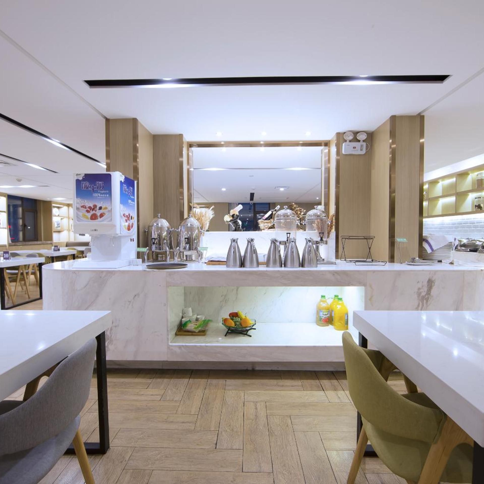 A modern cafe interior with marble counters, a coffee machine, and a fruit display.
