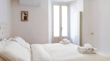 Una camera d'albergo con un letto, una finestra e una porta.