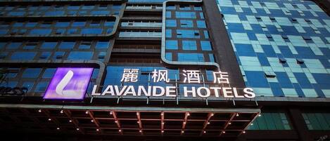 Exterior de Lavande Hotels con un diseño arquitectónico moderno, que cuenta con amplios ventanales y una señalización destacada.