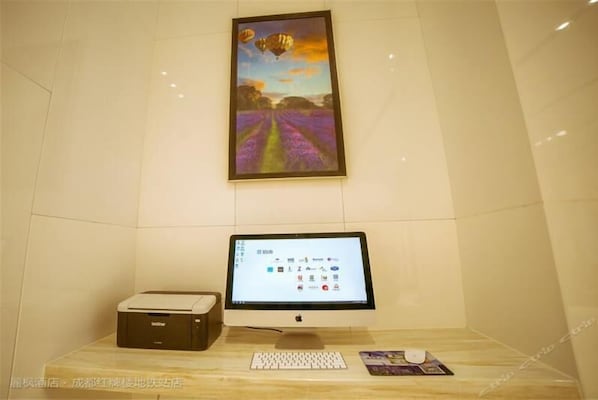 A desk with a computer, keyboard, and mouse, a printer, and a framed painting on the wall. - Lavande Hotel (Chengdu)