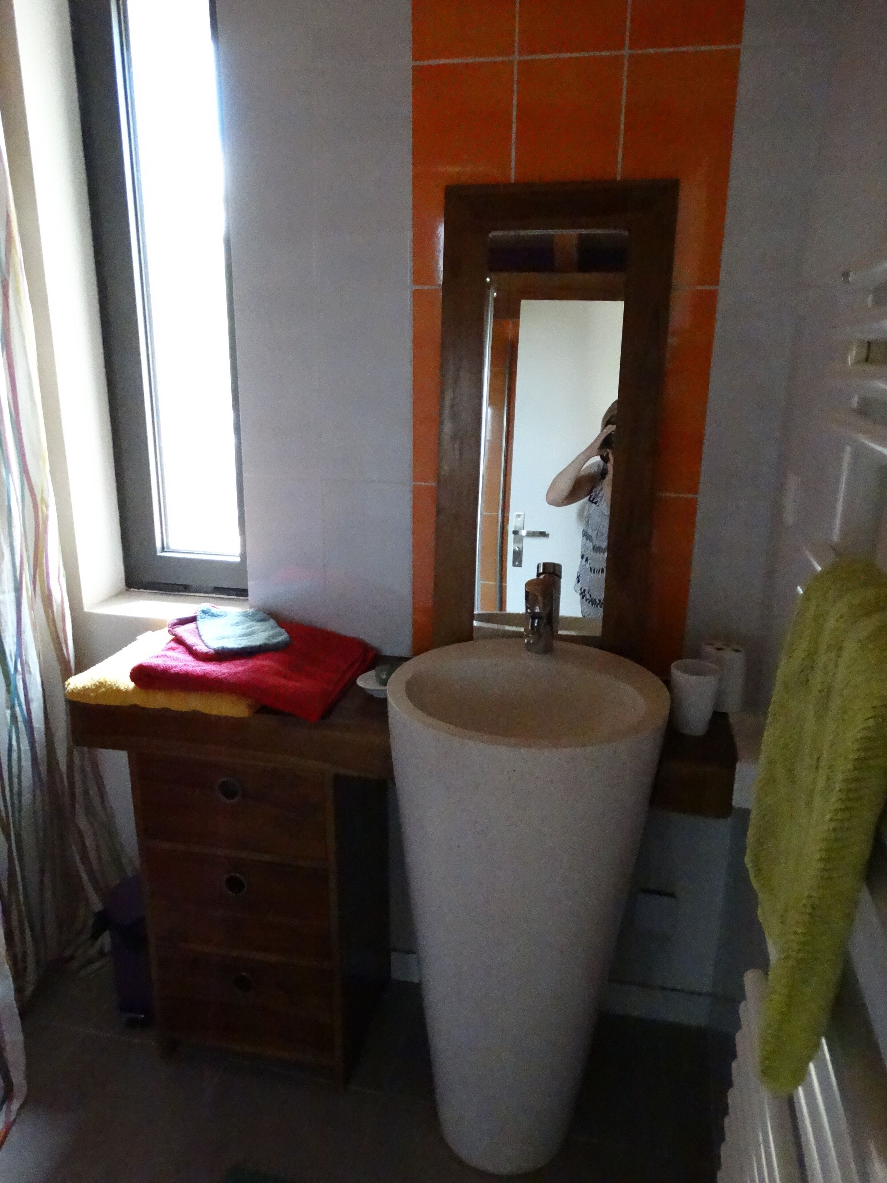 Un bany amb un lavabo gran, un mirall i una finestra.