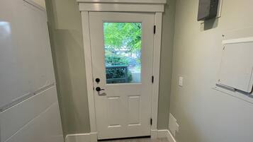 A white door with a glass panel, a small window, and a doorbell.