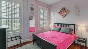 A bedroom with a bed, two nightstands, a dresser, and a window with blinds. - Stylish 2 BR apartment - perfect for relaxing! (Jacksonville)