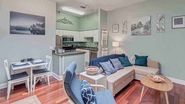 A compact living space with a kitchenette, a dining area, and a seating area with a sofa and a chair. - Stylish 2 BR apartment - perfect for relaxing! (Jacksonville)