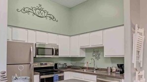 A modern kitchen with white cabinets, stainless steel appliances, and a granite countertop. - Stylish 2 BR apartment - perfect for relaxing! (Jacksonville)