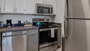 A modern kitchen with stainless steel appliances, including a refrigerator, oven, and microwave.