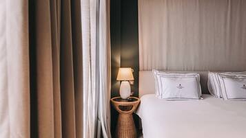 Un dormitorio con cama, lámpara y cortinas.