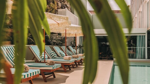 A poolside area with lounge chairs and umbrellas. - Torel Terra Brava (Angra do Heroismo)