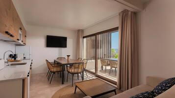 Habitación de hotel moderna con cocina, comedor y balcón con vistas.