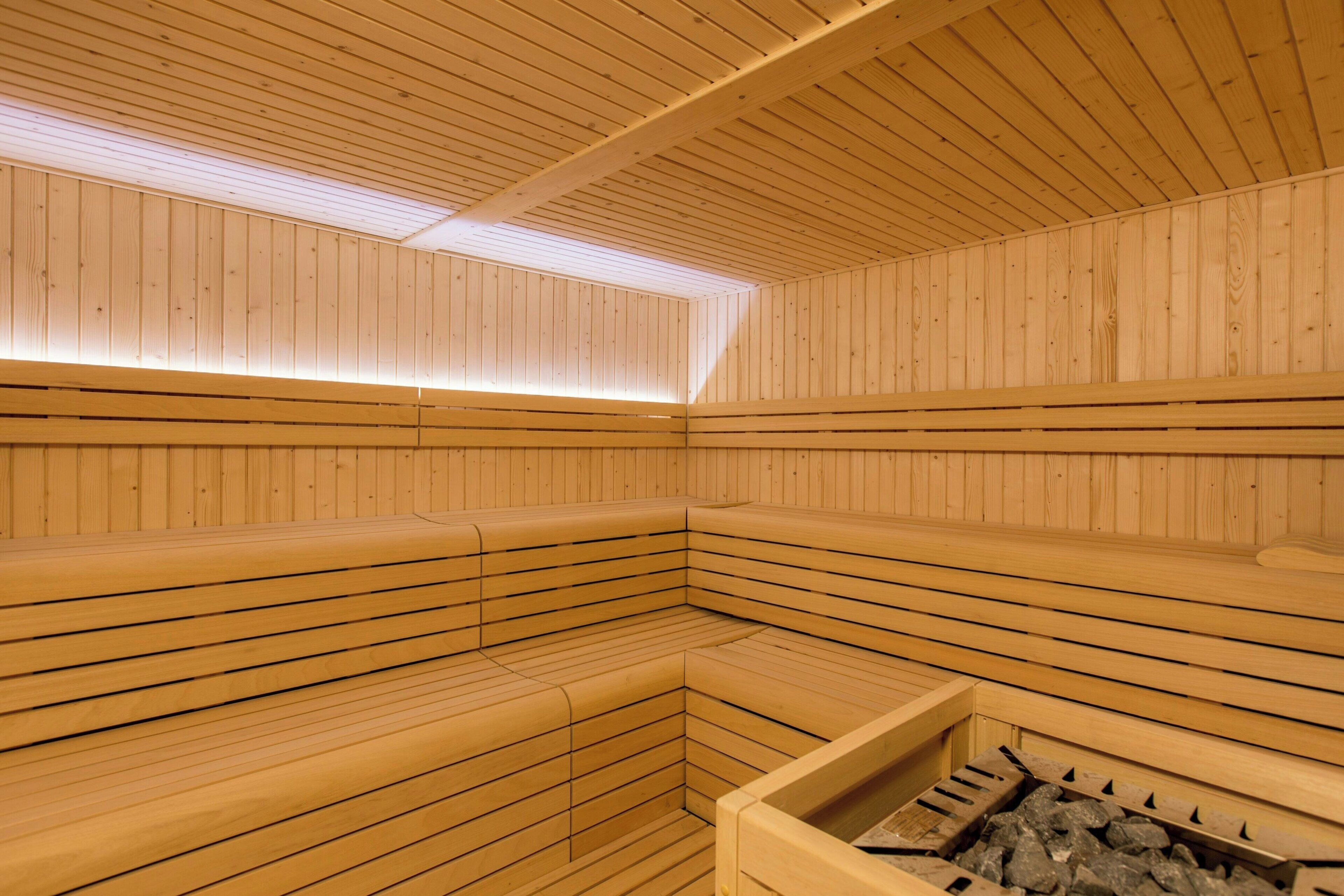 Una sauna con bancos de madera y un hogar a la vista.