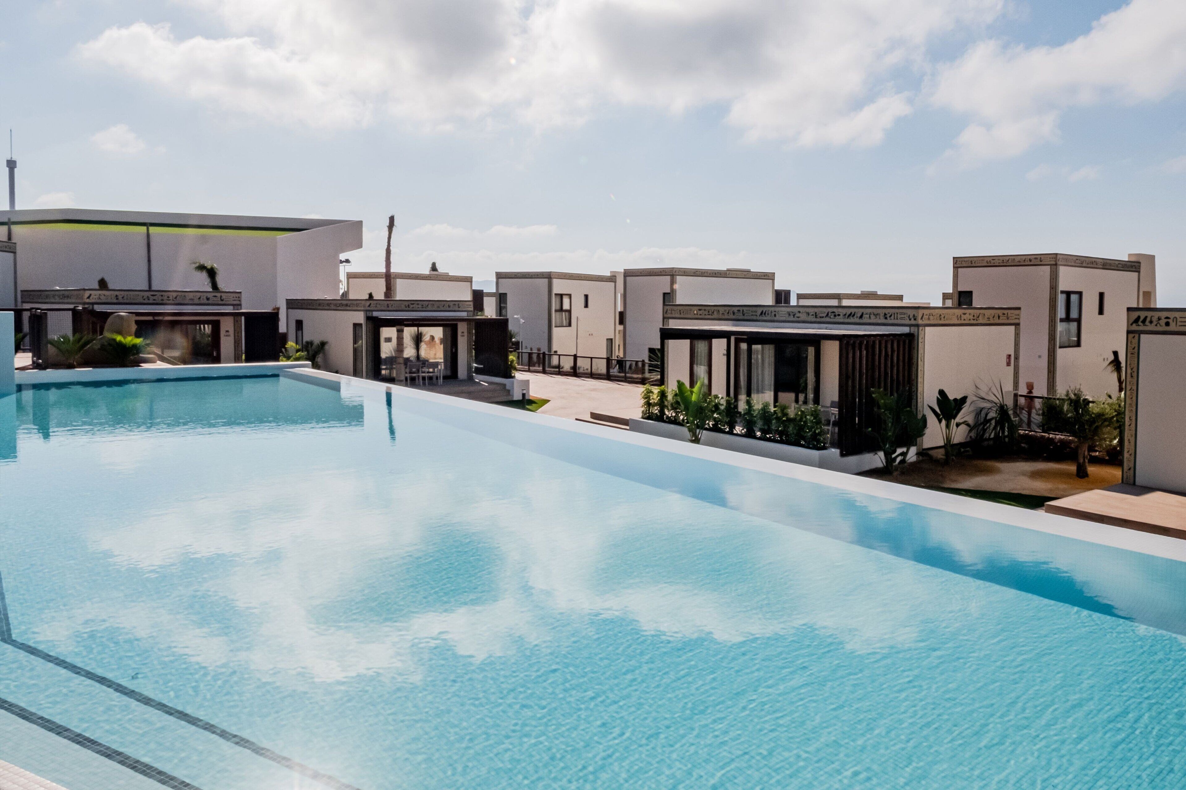 5 buitenzwembaden, ligstoelen bij het zwembad