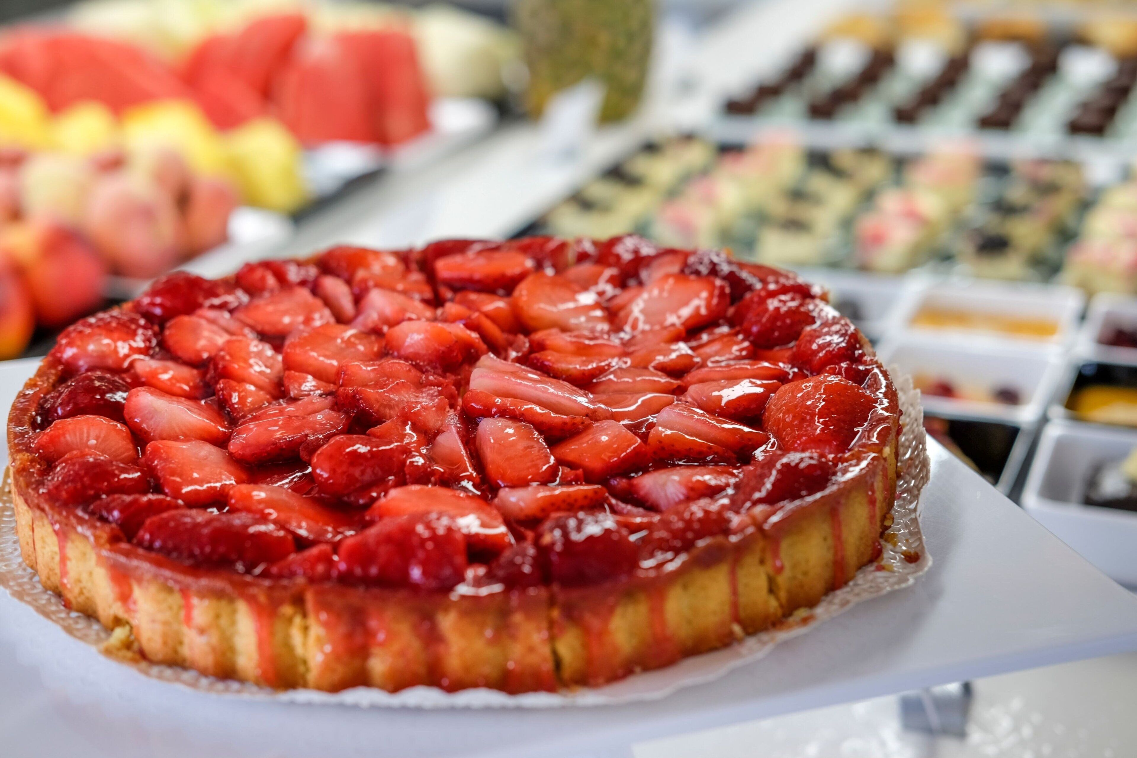 Ein runder Nachtisch mit Erdbeeren, serviert auf einem weißen Teller.
