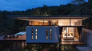 A modern, two-story house with a balcony and a bedroom visible. - Luxury modern Villa North Santa Teresa Walk To Surf (Santa Teresa Beach)