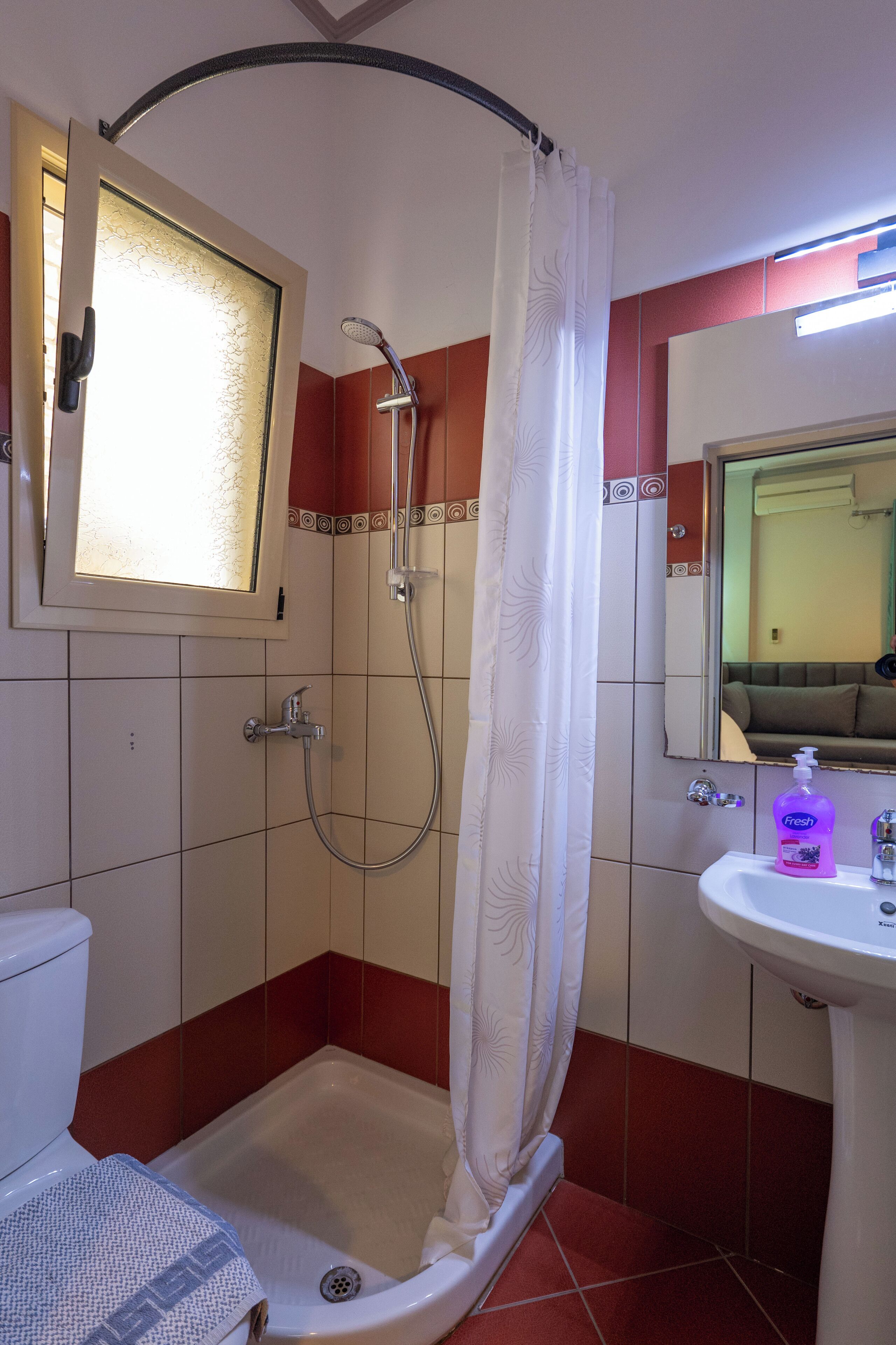 Een badkamer met een douche, toilet en wastafel.