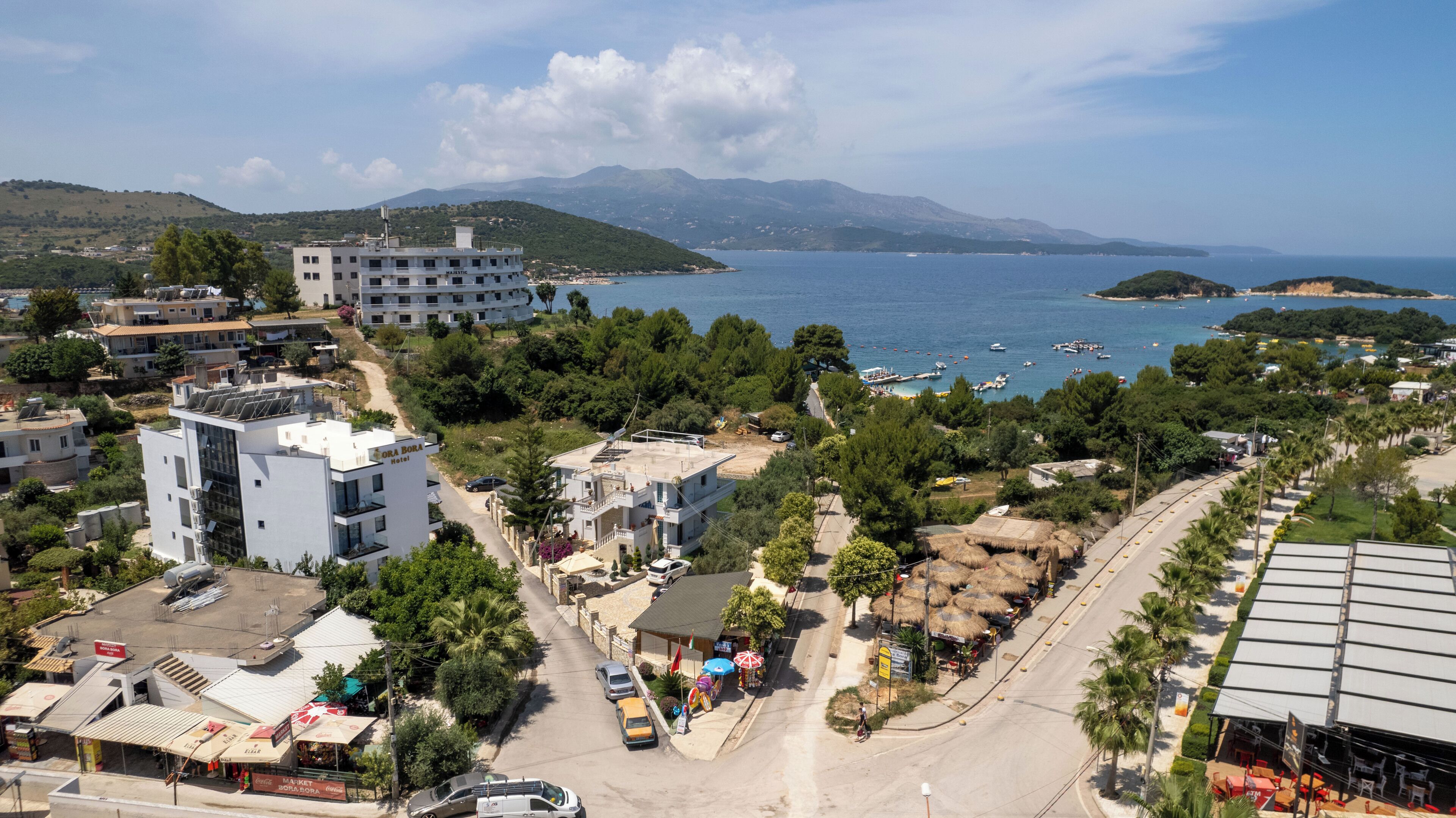 Un pueblo costero con un hotel llamado "Bora Bora Hotel" y un edificio que dice "MAJESTIC".