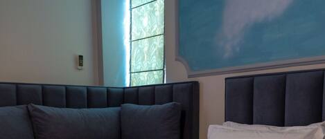 Een hotelkamer met een bed, een slaapbank en een raam met gordijnen.