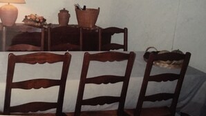 A dining area with wooden chairs, a table, a lamp, and a painting on the wall. - Villa sea view (Propriano)