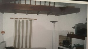 A bedroom with a bed, a nightstand, a lamp, a window with curtains, and a fireplace. - Villa sea view (Propriano)