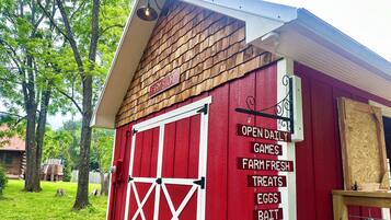 A red barn with a sign listing farm store offerings like eggs and bait.