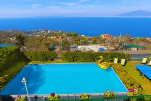 Une piscine avec vue sur la mer et un paysage montagneux en arrière-plan.