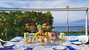 A table set for a meal with a view of the sea and mountains. - Villa Luisa play& pool (Massa Lubrense)