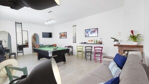 A living room with a pool table, a sofa, and a fireplace. - Villa Luisa play& pool (Massa Lubrense)