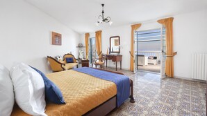 A bedroom with a bed, a desk, a chair, and a view of the outside. - Villa Luisa play& pool (Massa Lubrense)