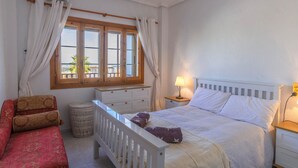 A bedroom with a bed, bedside table, lamp, and a view of the outdoors through a window. - Beautiful sunny top floor apartment in Ciudad Quesada, Rojales (Ciudad Quesada)