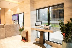 A reception area with a computer monitor, printer, and a plant. - Lavande Hotels Shenzhen North Railway Station Bantian Metro Station (Shenzhen)