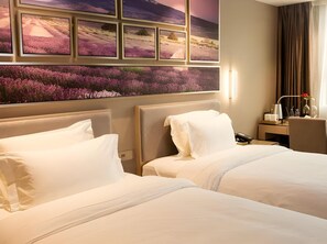 A hotel room with two beds, a large window with a view of a purple field, and a desk with a lamp and a vase of flowers. - Lavande Hotels Shenzhen North Railway Station Bantian Metro Station (Shenzhen)