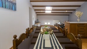 A dining area with a long table, chairs, and a central decorative piece. - Sky Corfu City View Loft (Corfu)