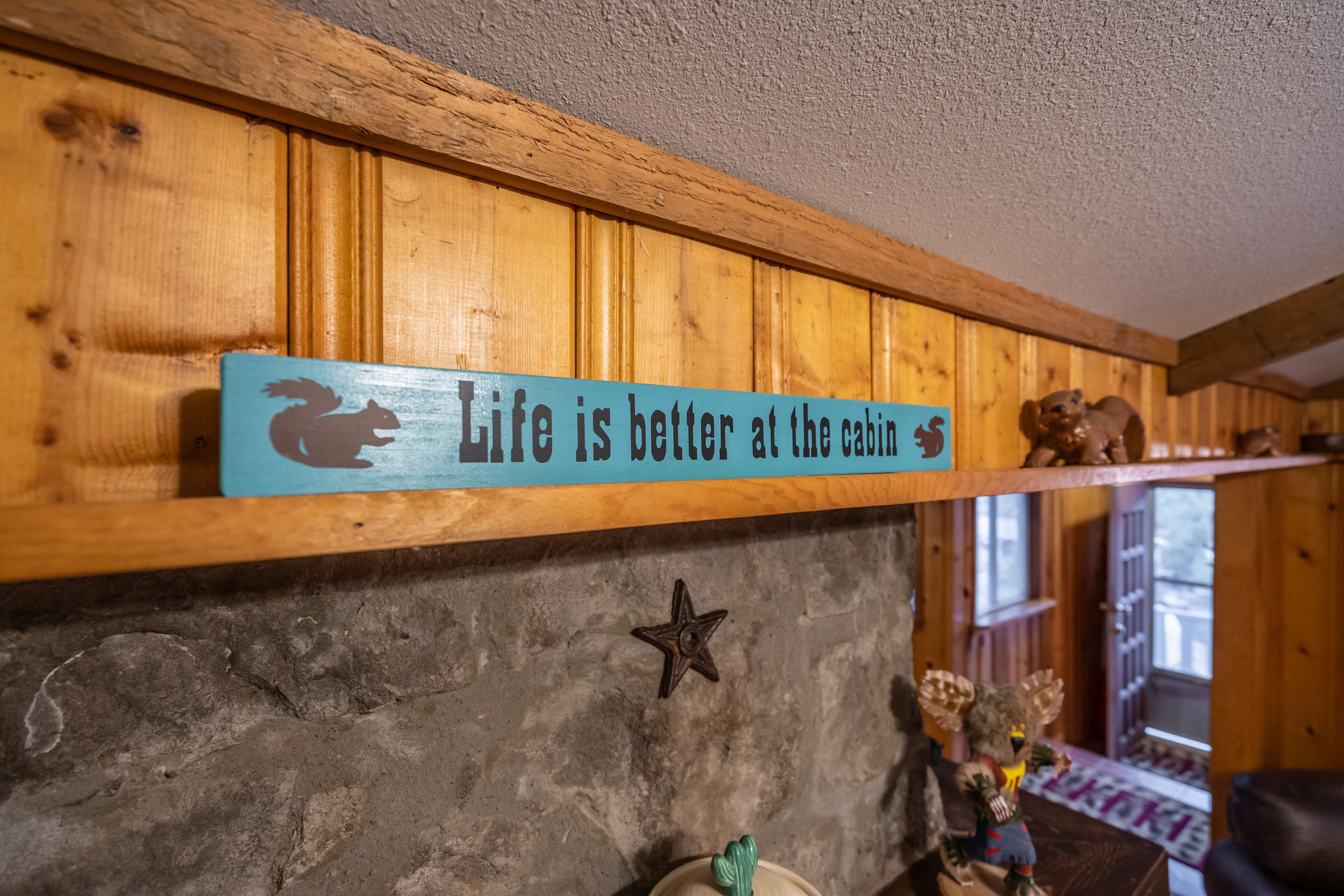 Uno scaffale di legno con un cartello che recita 'La vita è meglio alla baita'.