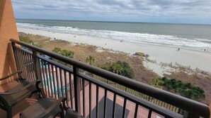 Ein Balkon mit Blick auf Strand und Meer.