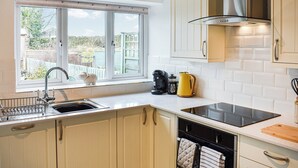 A kitchen with a window, sink, stove, and cabinets. - 2 bedroom accommodation in Clapham, near Ingleton (Clapham, near Ingleton)