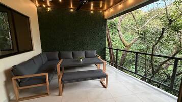 Un balcon agrémenté d’un mur végétal, d’un banc en bois et d’un canapé.