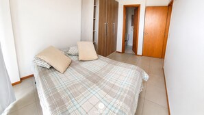 Un dormitorio con cama, armario y aire acondicionado.